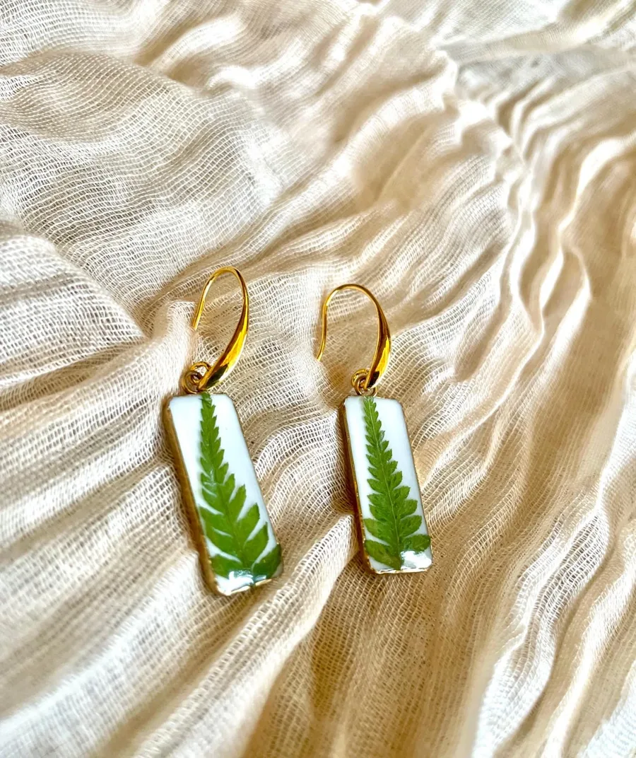 Boucles d'oreilles Étheria rectangulaires en résine blanche avec une feuille de fougère verte