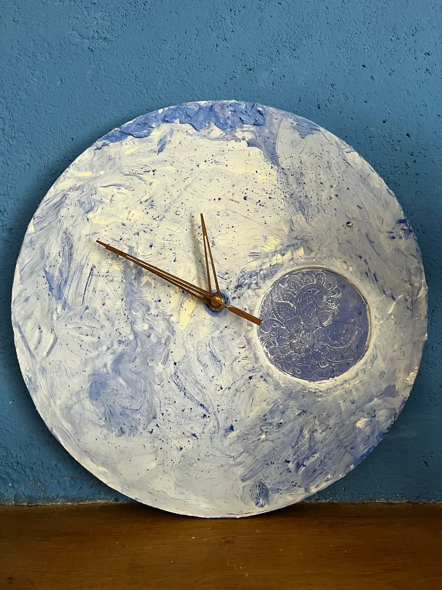 Horloge en résine minérale blanche et bleue réalisée à la main par Mylène, ornée d'une fleur